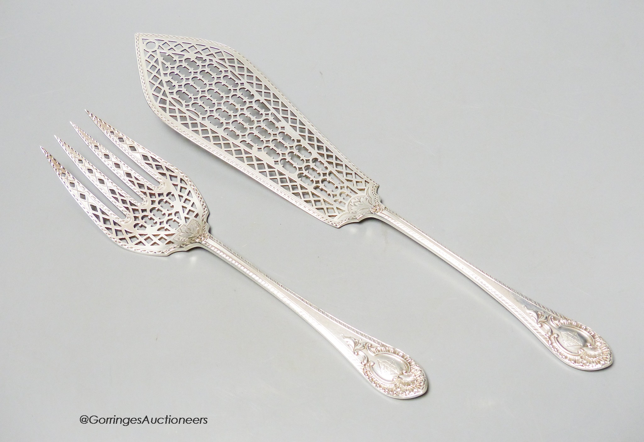 An ornate pair of Victorian engraved feather edge and pierced silver fish servers, by Martin, Hall & Co,Sheffield, 1868, knife 32.2cm, 7.5oz.